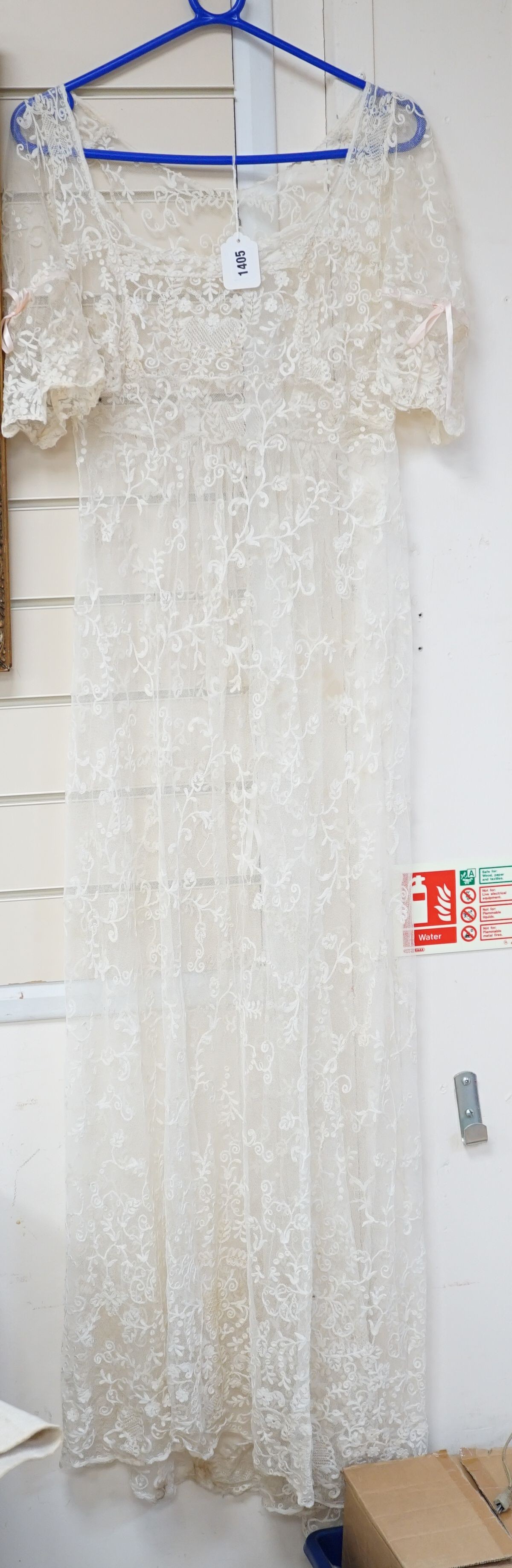 An early 20th century needle run on net lace wedding dress, 155 cms long.